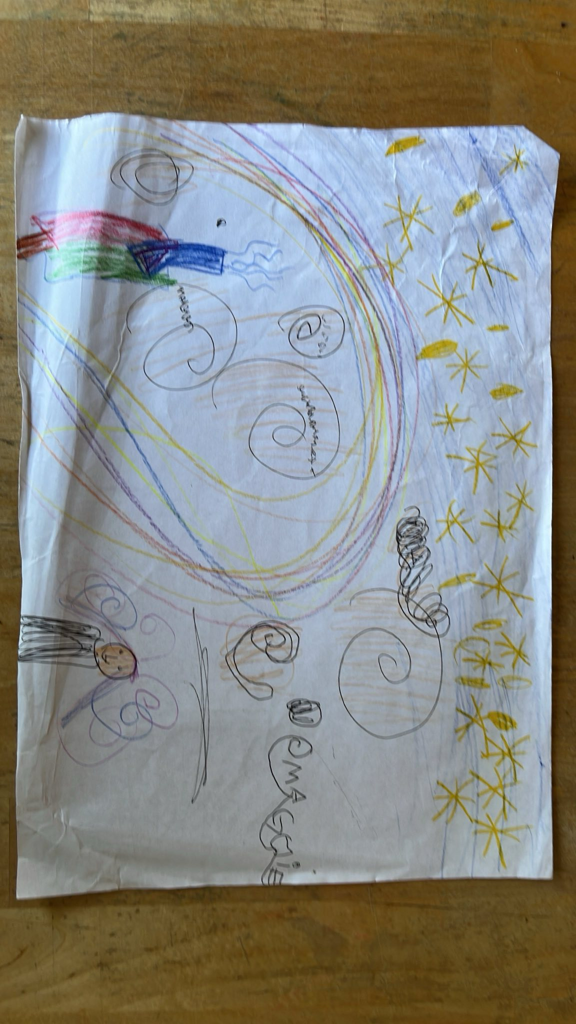 Child's magical drawing with rainbow swirls, stars, rocket, and stick figure with 'MAGIC' written on it